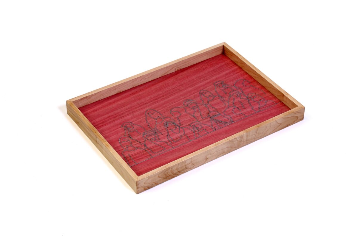 alt="Faces and figures in wire, wooden tray with red background "