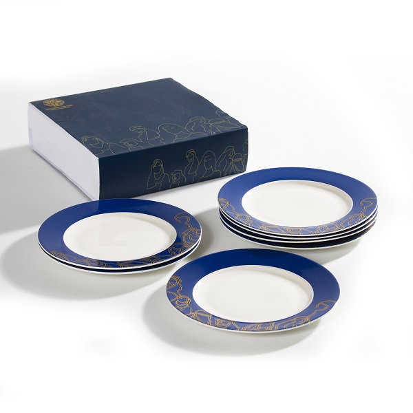 Bread and dessert plates with golden faces and figures on navy background