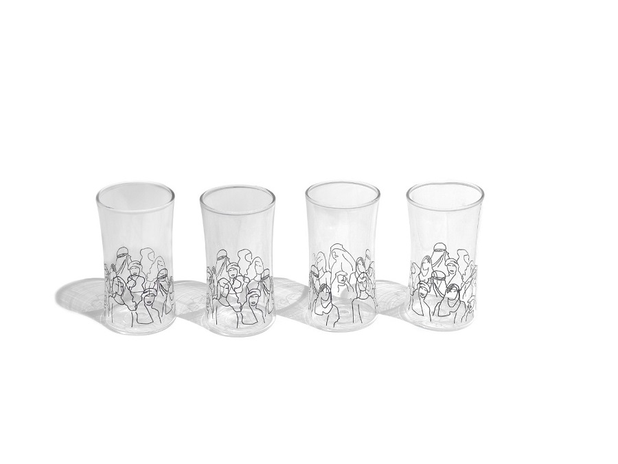 alt="double glass water cups with black faces and figures"