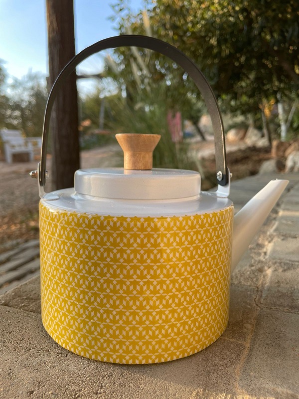 alt="yellow tea pot with designs"