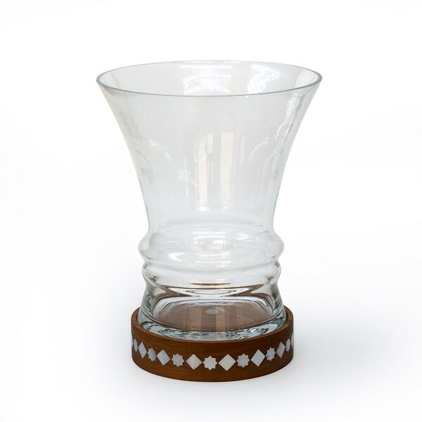 alt="clear glass vase with wood and mother of pearl base"